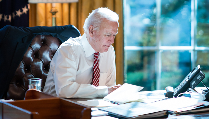 Joe Biden at desk, looking over documents