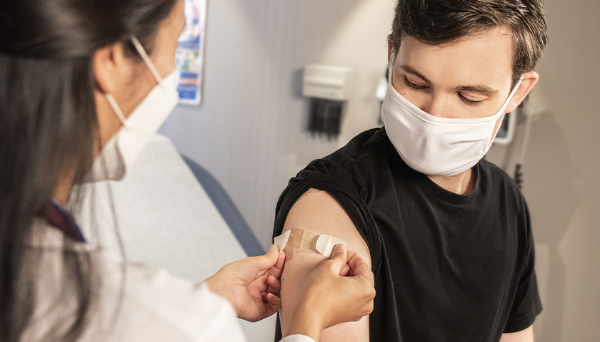 Man getting bandaid on vaccination shot
